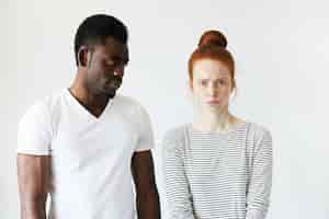 Photo gratuite homme africain en t-shirt blanc et femme de race blanche rousse en haut rayé