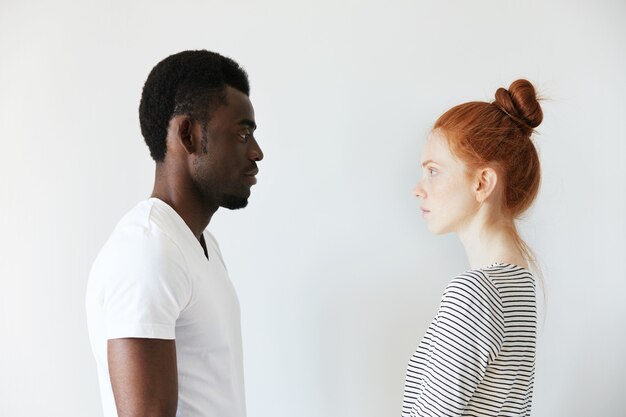 Homme africain en T-shirt blanc et femme de race blanche rousse en haut rayé