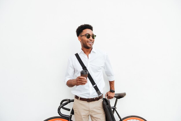 Homme africain avec vélo boire du café.