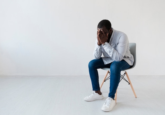 Photo gratuite homme afro-américain assis sur une chaise