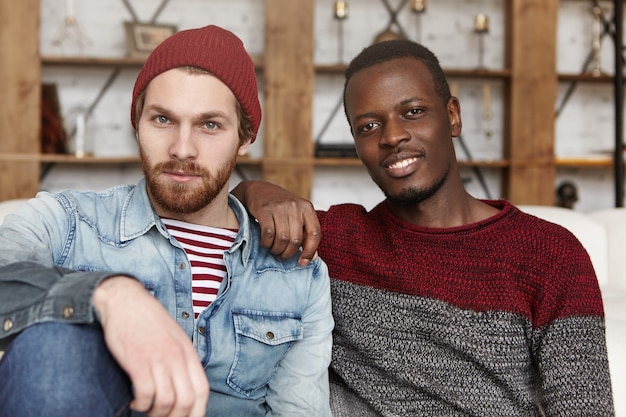 Photo gratuite homme afro-américain coude au repos sur l'épaule de son ami élégant