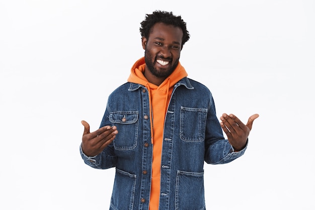 Homme afro-américain élégant et confiant en veste en jean, sweat à capuche orange, attrapant les vibrations des vacances d'automne