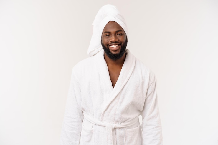 Photo gratuit homme afro-américain portant un peignoir avec surprise et émotion heureuse isolé sur fond blanc