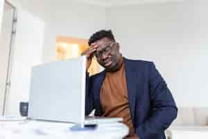 Photo gratuite homme afro-américain stressé et fatigué touchant les temples souffrant de maux de tête après de longues heures de travail surmené homme d'affaires débordé assis au bureau se sentant mal