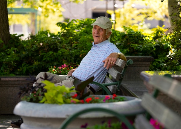 Photo gratuite homme âgé assis sur un banc à l'extérieur