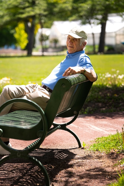 Photo gratuite homme âgé assis sur un banc à l'extérieur