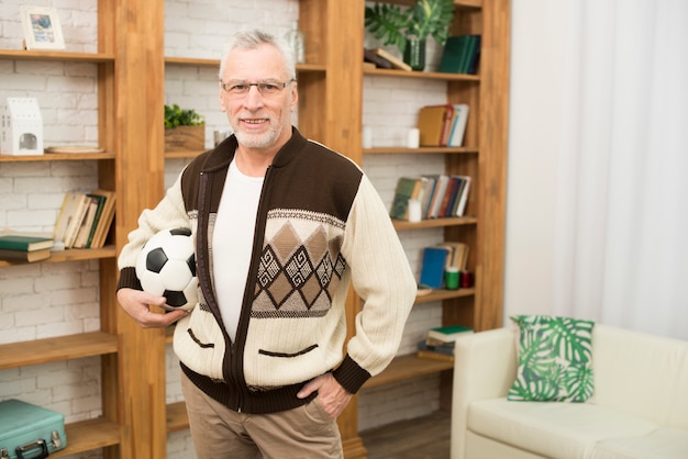 Photo gratuite homme âgé avec ballon près d'étagères dans la chambre