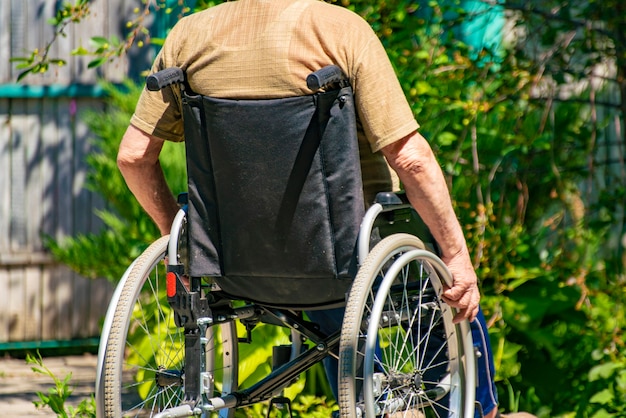 Homme âgé handicapé dans la chaise au chalet de campagne, maladies des personnes âgées