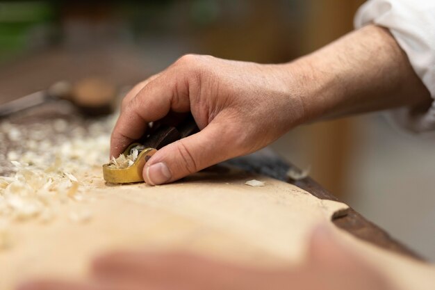 Homme d'âge moyen fabriquant des instruments dans son atelier seul