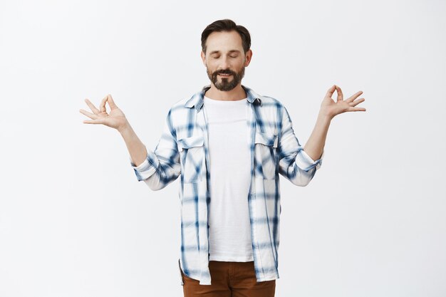 Homme d'âge mûr barbu calme et détendu posant