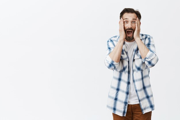 Homme d'âge mûr barbu surpris et amusé posant