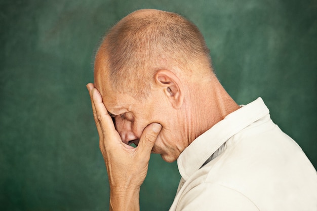 Homme d'âge mûr inquiet touchant sa tête.