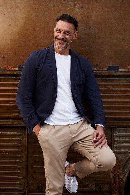 homme d'âge mûr portant sourire sur un fond de couleur rouillée