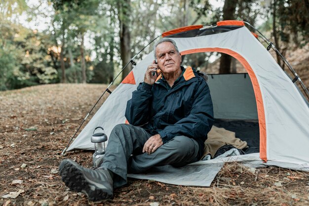 Homme âgé à la recherche d'une connexion internet dans la forêt