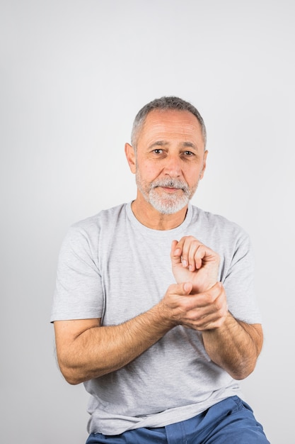 Homme âgé tenant son portrait de la main