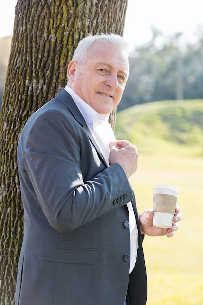 Photo gratuite homme âgé tranquille posant avec un café