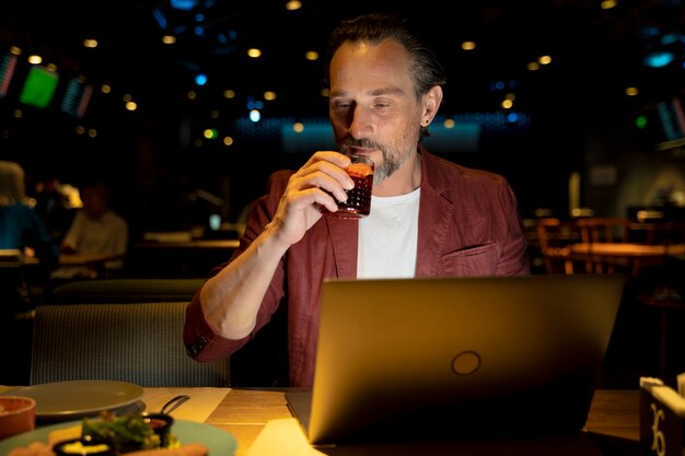 Homme âgé travaillant sur son ordinateur portable dans un restaurant