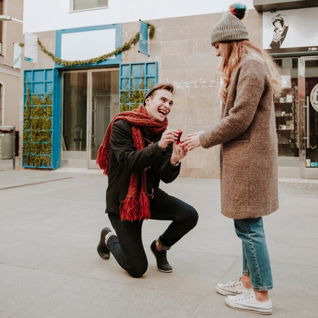 Homme agenouillé faisant une proposition