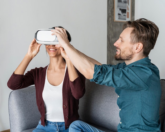 Homme aidant la femme à mettre le casque de réalité virtuelle