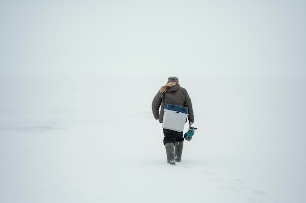 Photo gratuite l'homme à l'aide d'une boîte pour le poisson qu'il a attrapé