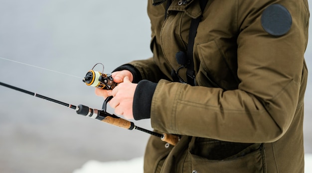 Photo gratuite homme à l'aide d'une canne à pêche