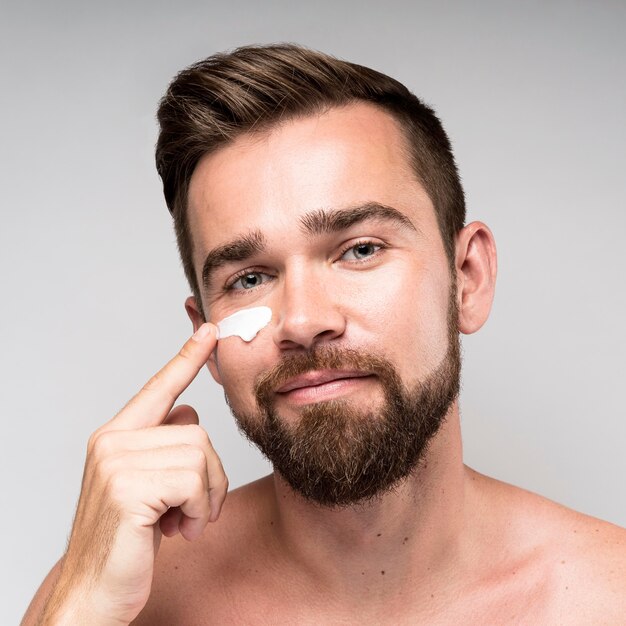 Homme à l'aide de crème pour le visage