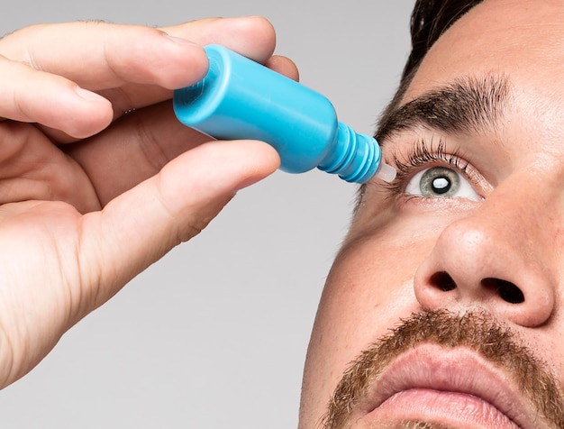 Homme à l'aide de gouttes pour les yeux close-up