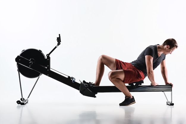 Homme à l'aide d'une machine de presse dans un club de remise en forme.