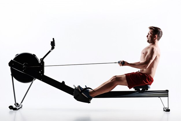 Homme à l'aide d'une machine de presse dans un club de remise en forme.