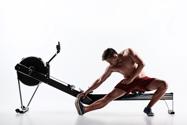 Homme à l'aide d'une machine de presse dans un club de remise en forme.