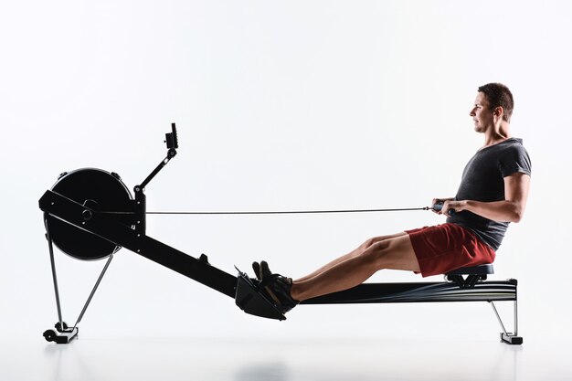 Homme à l'aide d'une machine de presse dans un club de remise en forme.