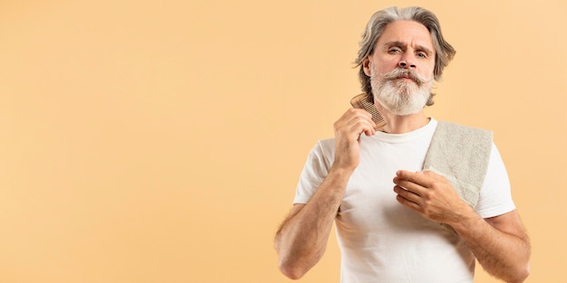 Homme aîné, à, serviette, peigner sa barbe