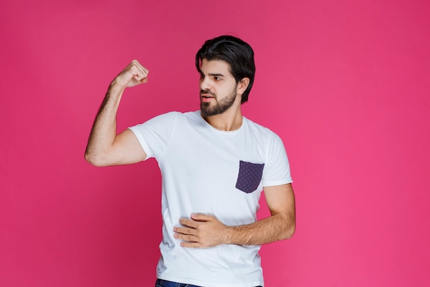 L'homme a l'air positif et effrayant sur le mur rose.