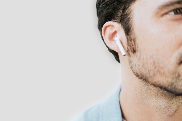 Homme américain écoutant de la musique sur des écouteurs sans fil en gros plan