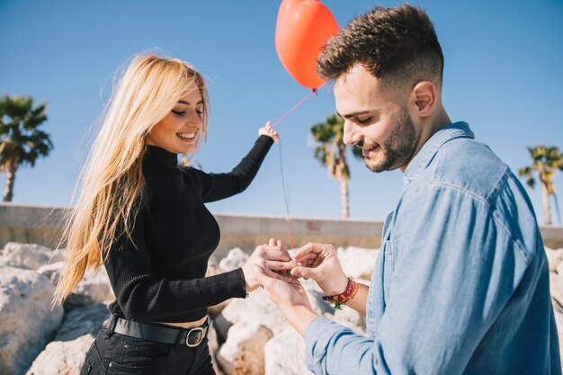 Homme amoureux mettant la bague sur la main des filles