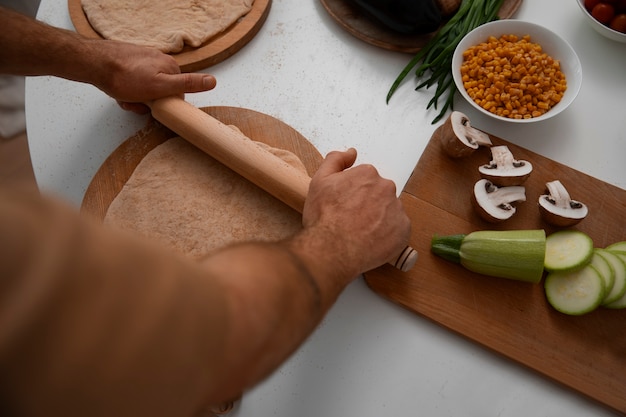 Photo gratuite homme à angle élevé cuisinant une pizza