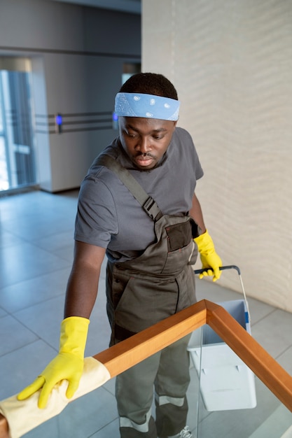 Homme à angle élevé nettoyant la balustrade