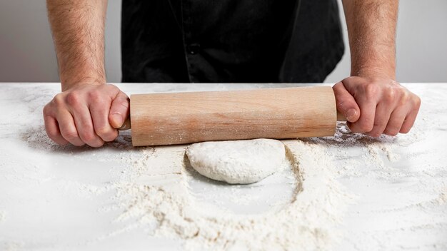 Homme à angle élevé, rouler la pâte à pizza