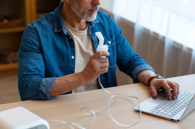 Homme à angle élevé utilisant un nébuliseur