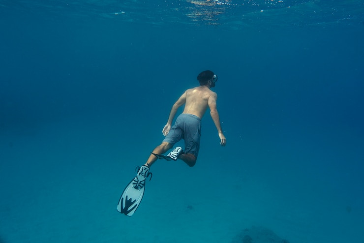 Photo gratuit homme apnée avec palmes sous l'eau
