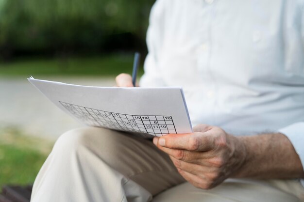 Homme appréciant un jeu de sudoku sur papier par lui-même