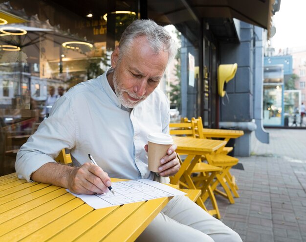 Homme appréciant un jeu de sudoku sur papier