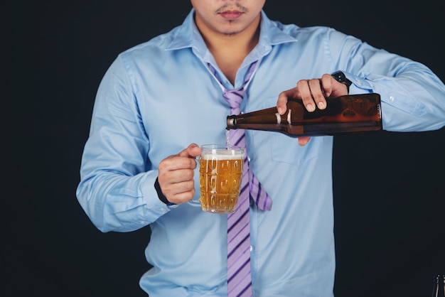 homme asiatique buvant une chope de bière