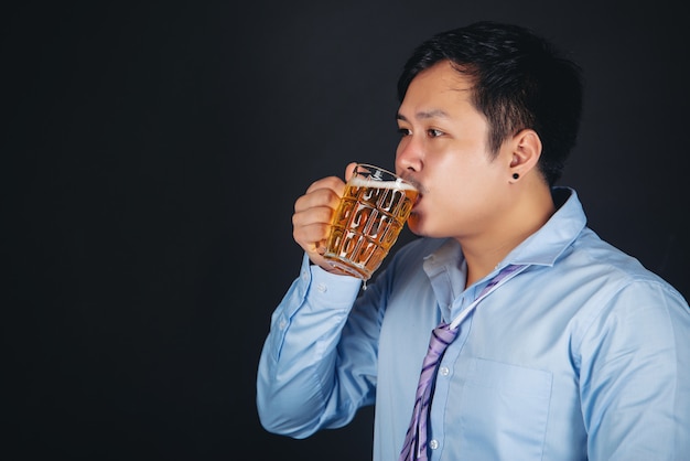 homme asiatique buvant une chope de bière