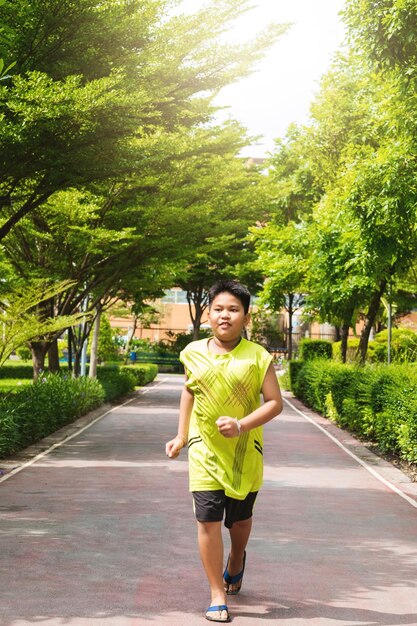 Homme asiatique faisant du jogging dans le parc le matin ensoleillé