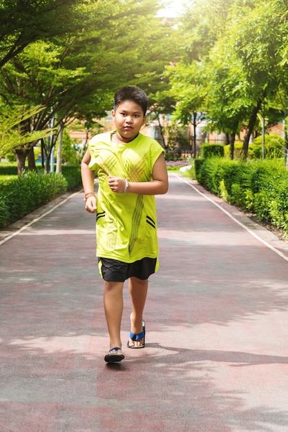 Homme asiatique faisant du jogging dans le parc le matin ensoleillé