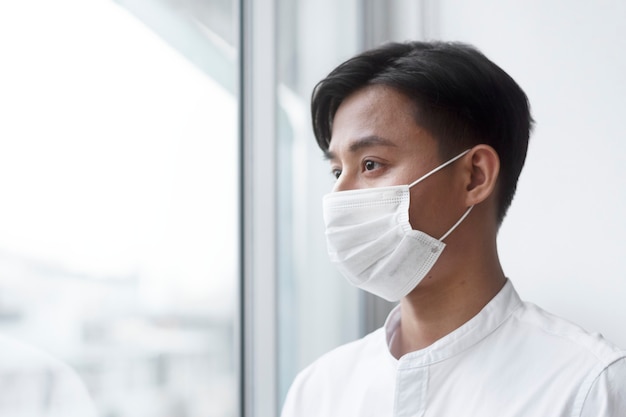 Homme asiatique portant un masque facial à la maison