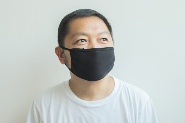 Homme asiatique portant un masque médical noir