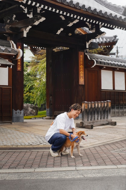 Photo gratuite homme asiatique avec son chien shiba inu à l'extérieur