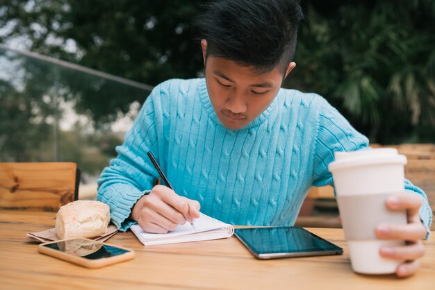 Homme asiatique, utilisation, tablette numérique, et, prendre notes